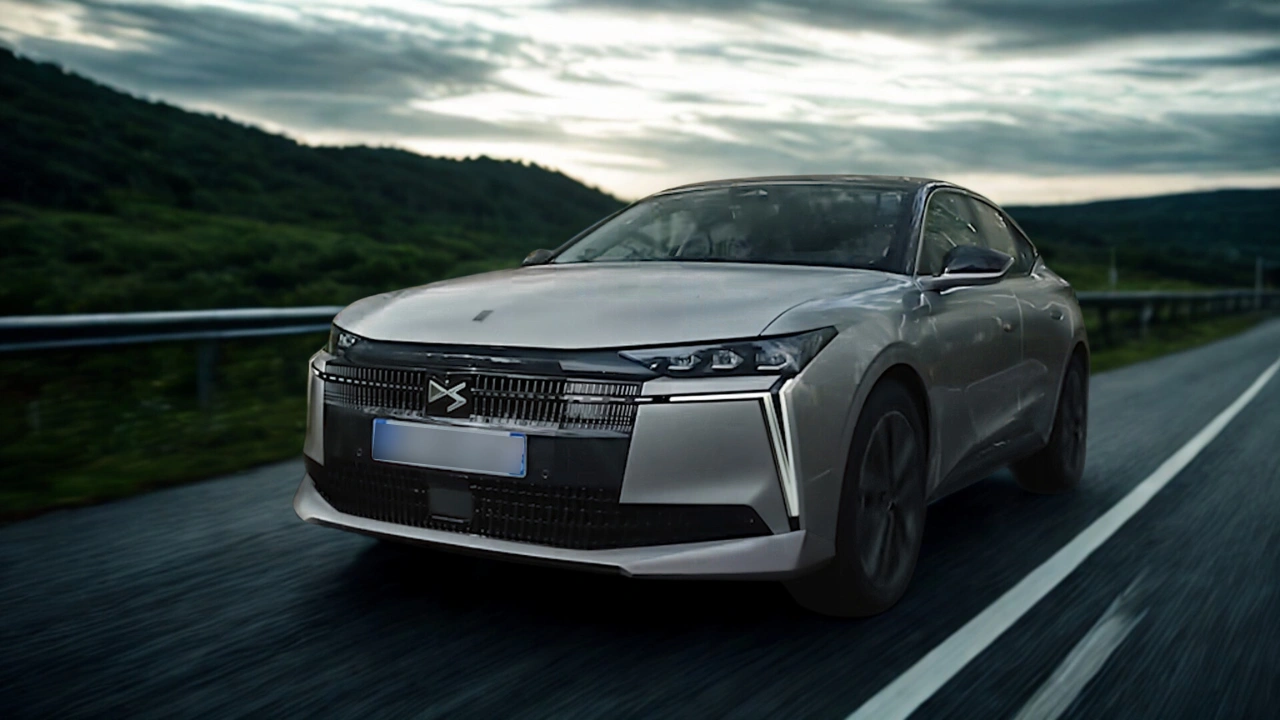 De DS No. 4 in beweging, met nadruk op zijn overheersende wegaanwezigheid met de verlengde motorkap, bredere stance, en aerodynamisch voorzijde design dat technologie en elegantie combineert.