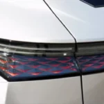 Extreme close-up van de innovatieve LED achterlicht technologie van de DS No. 4 met de nieuwe Dark Chrome cover met lasergegraveerd schubbenreliëf patroon dat licht vangt en een verbluffend visueel effect creëert, wat de fusie van elegantie en technologie vertegenwoordigt.