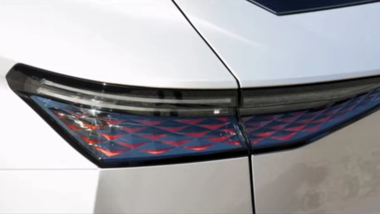 Extreme close-up van de innovatieve LED achterlicht technologie van de DS No. 4 met de nieuwe Dark Chrome cover met lasergegraveerd schubbenreliëf patroon dat licht vangt en een verbluffend visueel effect creëert, wat de fusie van elegantie en technologie vertegenwoordigt.