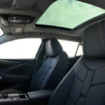 Panoramisch zicht op het voorinterieur van de DS No. 4 met de premium lederen sportstoelen met onderscheidend gestikt design, panoramisch glazen dak dat de cabine vult met natuurlijk licht, 10,25-inch digitaal instrumentenpaneel, 10-inch infotainment touchscreen, met leder bekleed stuurwiel, en verfijnd Frans interieur vakmanschap met Clous de Paris detaillering.