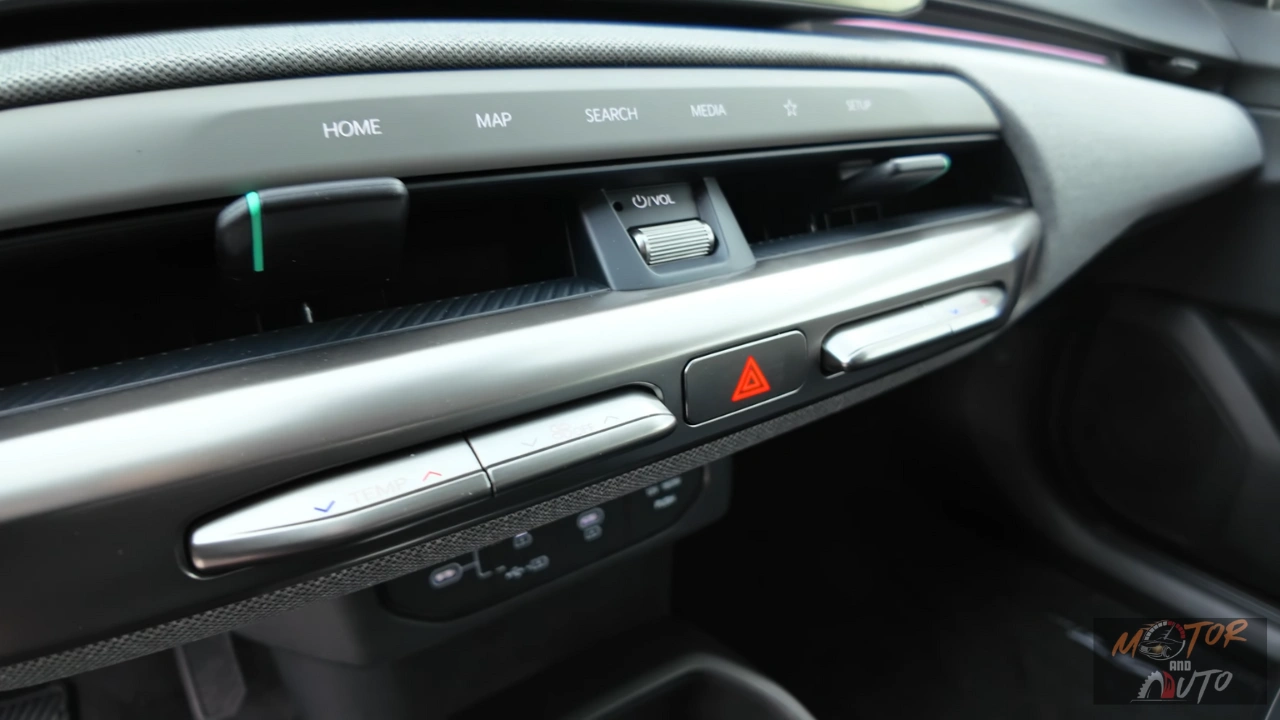 Het dashboard van de 2026 Kia EV4 heeft een modern middenpaneel met HOME, MAP, SEARCH, MEDIA knoppen en geïntegreerde volumeknop