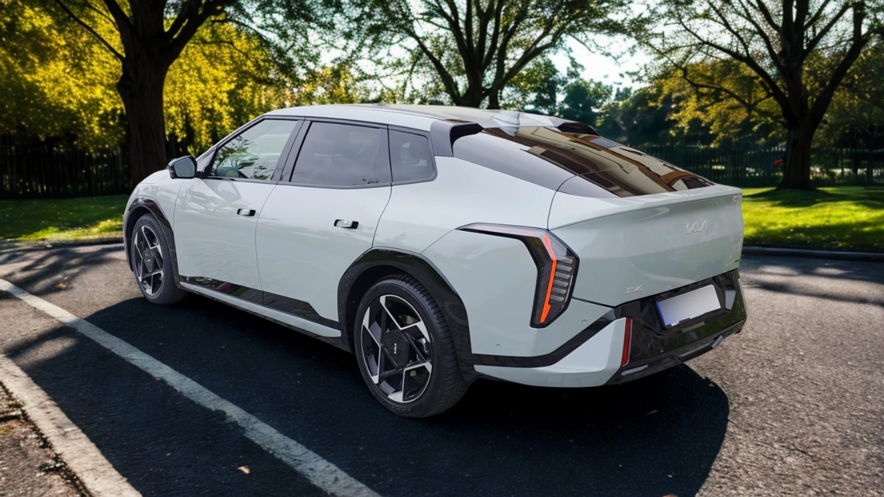 De 2026 Kia EV4 in Snow White Pearl toont zijn kenmerkende fastback-profiel en verbonden LED-achterlichten in een natuurlijke omgeving
