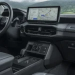 Passagierszijde van het dashboard van de 2026 Toyota Hilux BEV met de shift-by-wire middenconsole en 12,3-inch scherm.