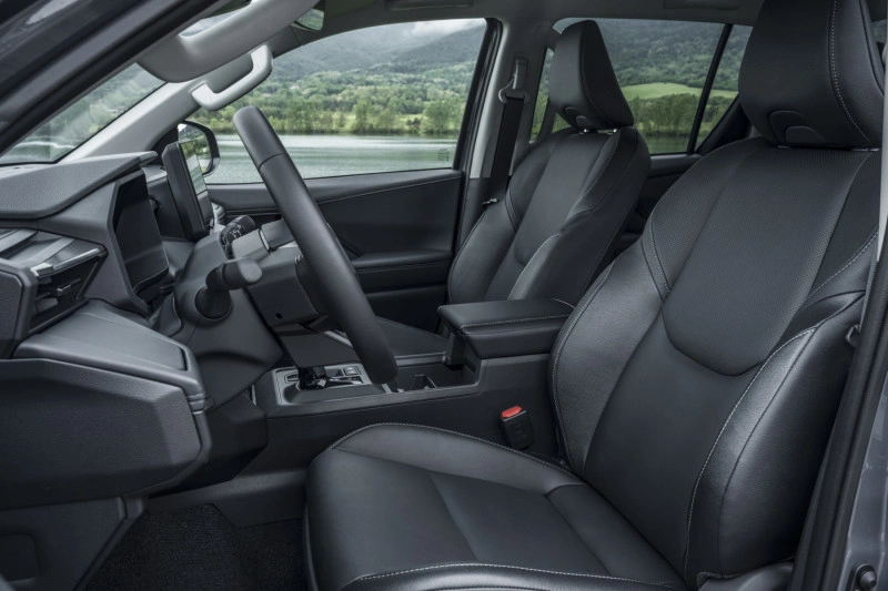 Lederen voorstoelen en stuurwiel in de 2026 Toyota Hilux BEV Double Cab met zwarte bekleding.