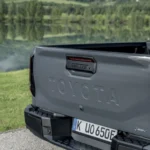 Achterklep van de 2026 Toyota Hilux BEV in Ash Grey met gestanste TOYOTA-letters, HILUX-lichtbalk en Duitse kentekenplaat.