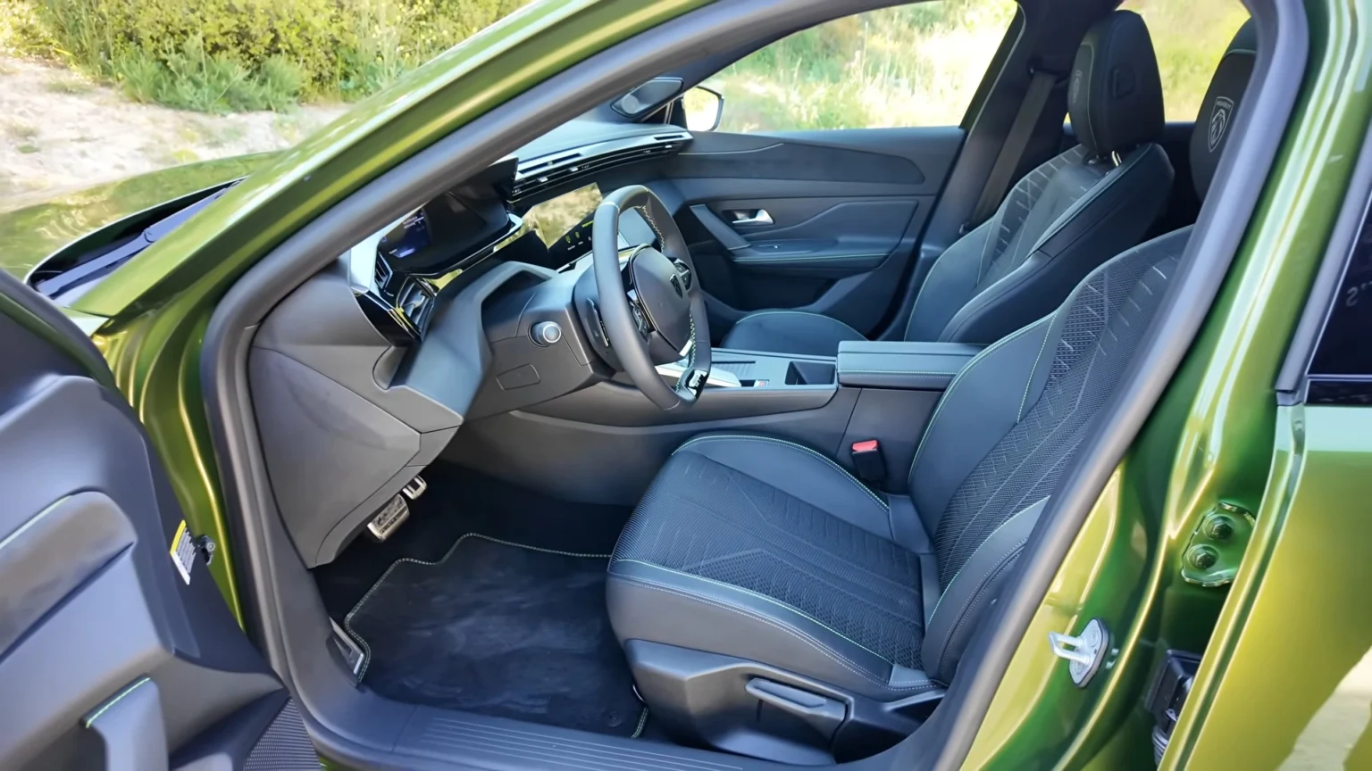 Voorstoelen van de 2026 Peugeot 408 GT door de open bestuurdersdeur.