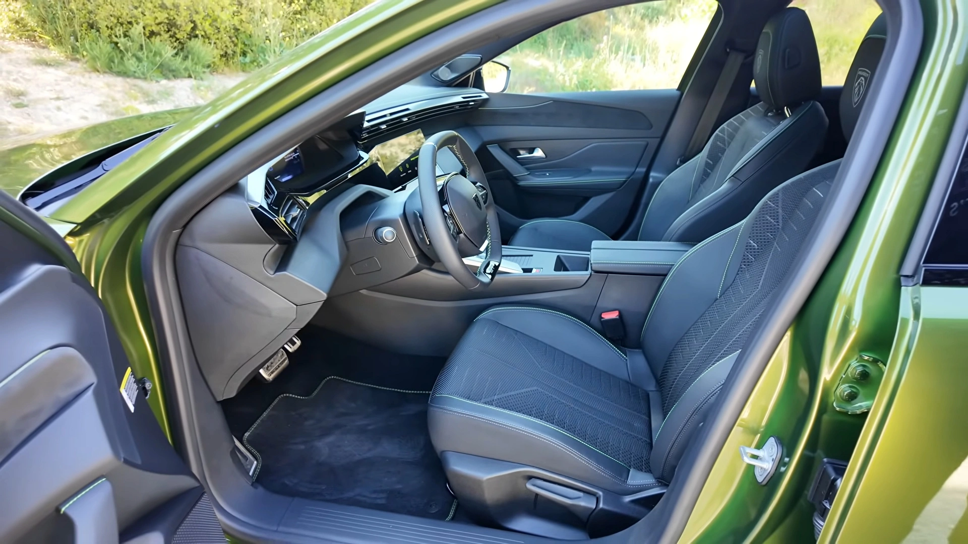 Voorstoelen van de 2026 Peugeot 408 GT door de open bestuurdersdeur.