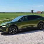 Groene 2026 Peugeot 408 schuin vooraanzicht bij een molen en weiland.