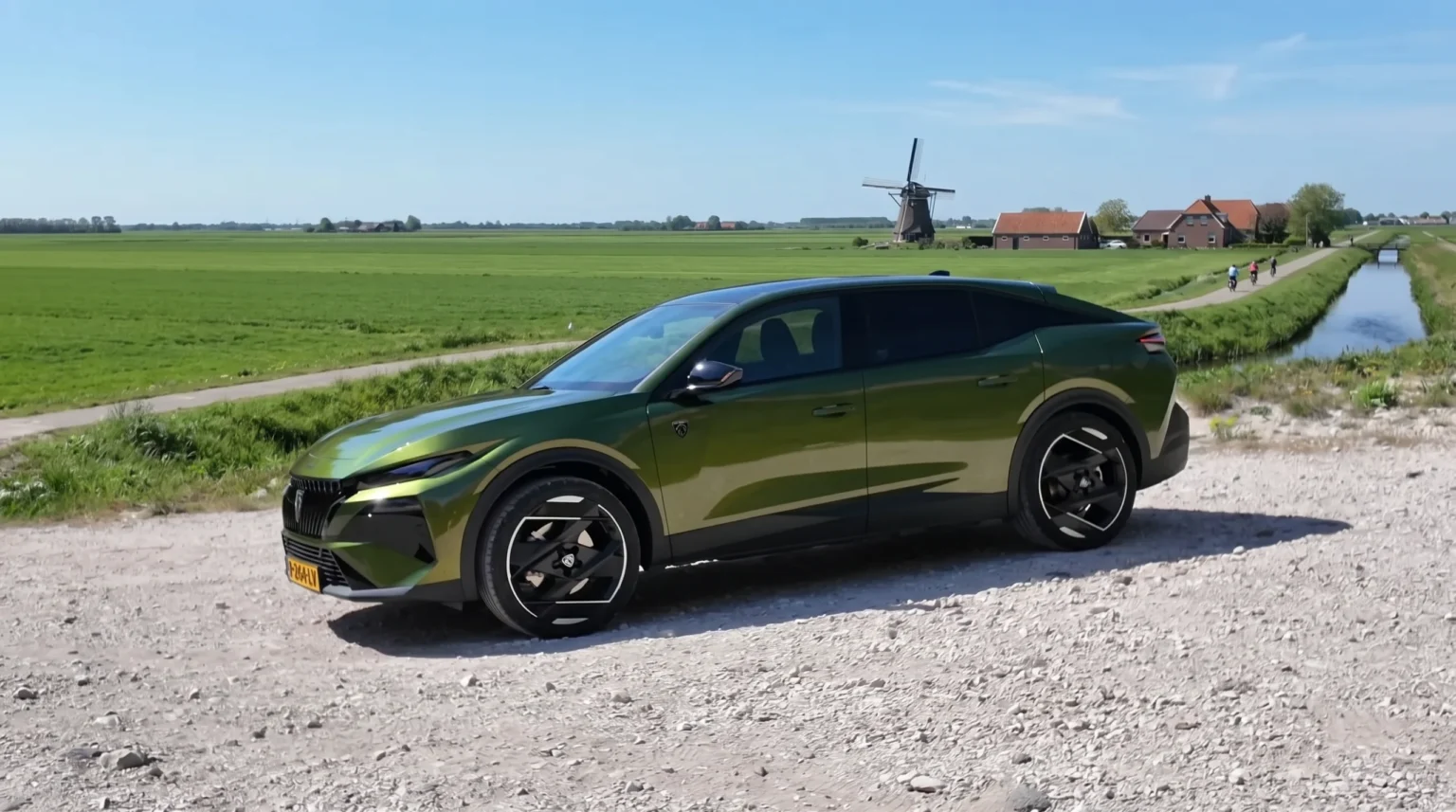 Groene 2026 Peugeot 408 schuin vooraanzicht bij een molen en weiland.