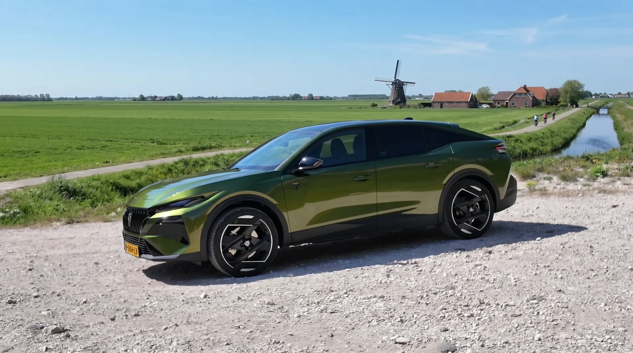 Groene 2026 Peugeot 408 schuin vooraanzicht bij een molen en weiland.