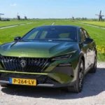 Groene 2026 Peugeot 408 vooraanzicht met meerdere molens over de velden.