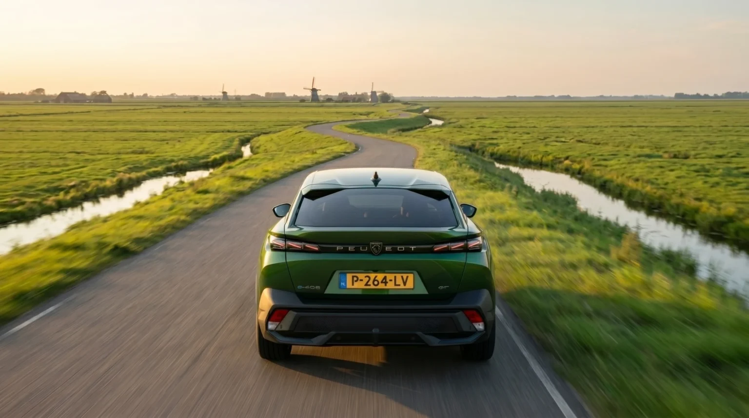 Achteraanzicht van een groene 2026 Peugeot 408 op een kronkelweg door weiland.