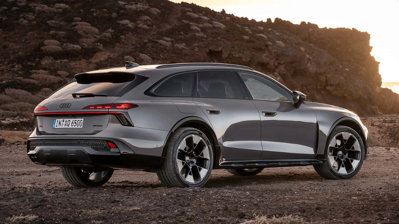 Grijze Audi A6 Allroad driekwart achteraanzicht op ruig kustlandschap