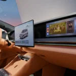 Close-up van BYD Great Tang dashboard met bestuurdersscherm, centraal infotainmentscherm en passagiersscherm.