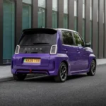 Achteraanzicht schuin van een paarse Honda Super-N elektrische stadsauto langs de stoeprand.